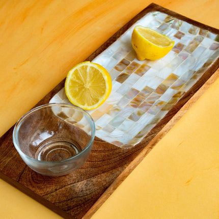 Casa Duniya's Wooden Mother of Pearl Lulu Serving Tray with Glass Bowl and Lemons Against a Yellow Background