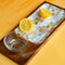 Casa Duniya's Wooden Mother of Pearl Lulu Serving Tray with Glass Bowl and Lemons Against a Yellow Background