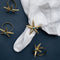 Casa Duniya's Gold and Turquoise Starfish Napkin Rings on a White Napkin and Blue Background