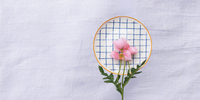Casa Duniya's White and Blue Checkered Zambila Dessert Plate with a Pink Flower and White Linen Background